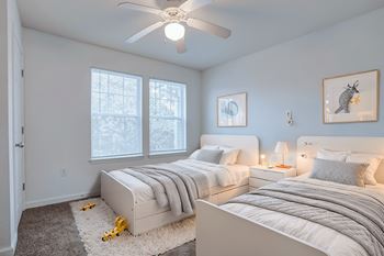 A bedroom with two beds and a ceiling fan.